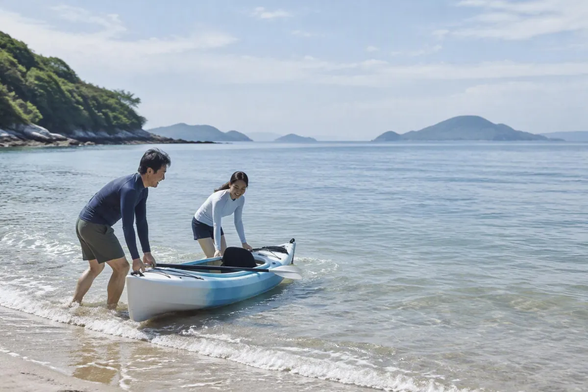 イメージ画像：平日の昼、瀬戸内の浜辺で2人がカヤックを海へ押し出している