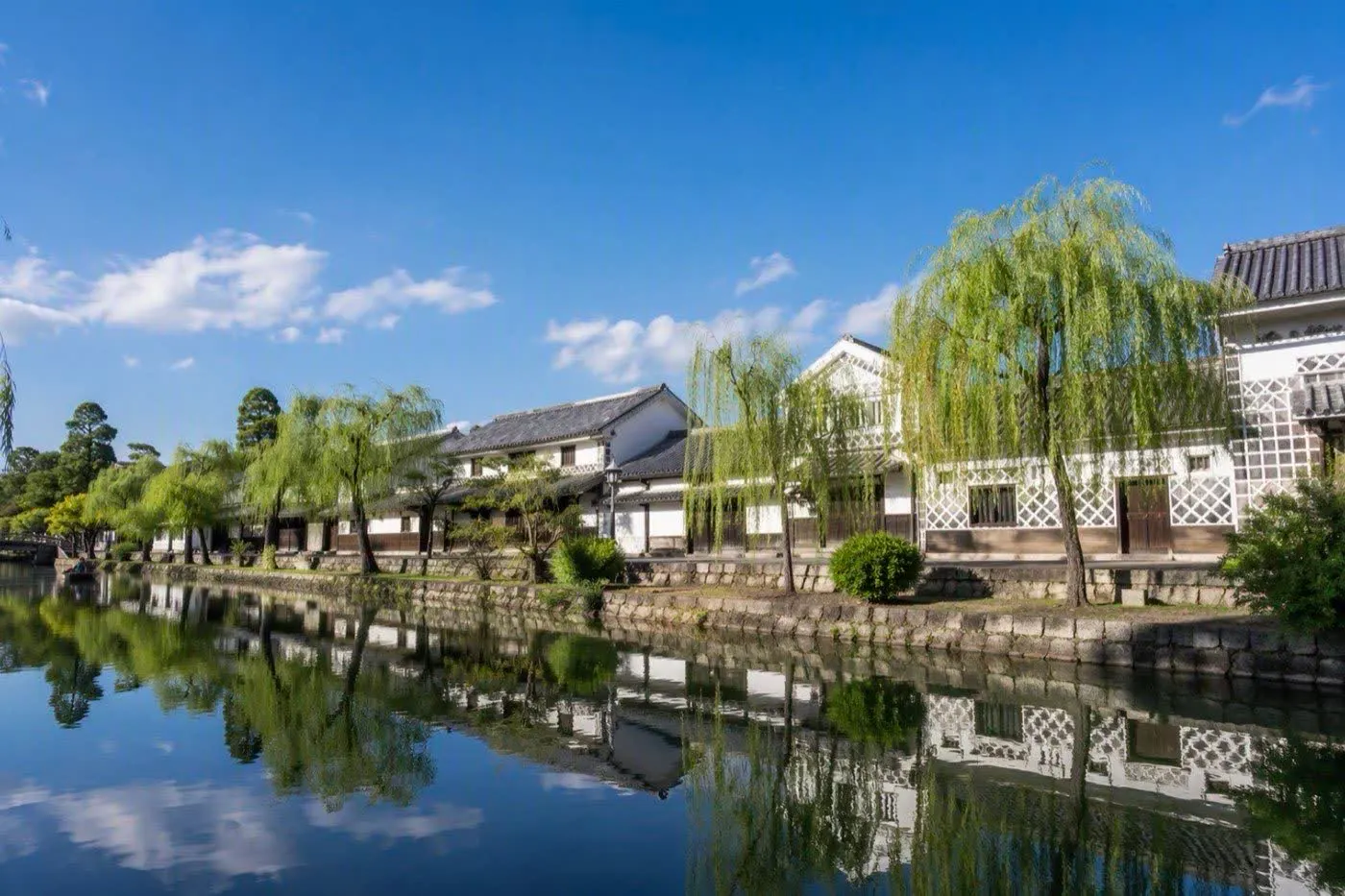 イメージ画像：白壁の蔵と柳並木が続く、川沿いの町並み