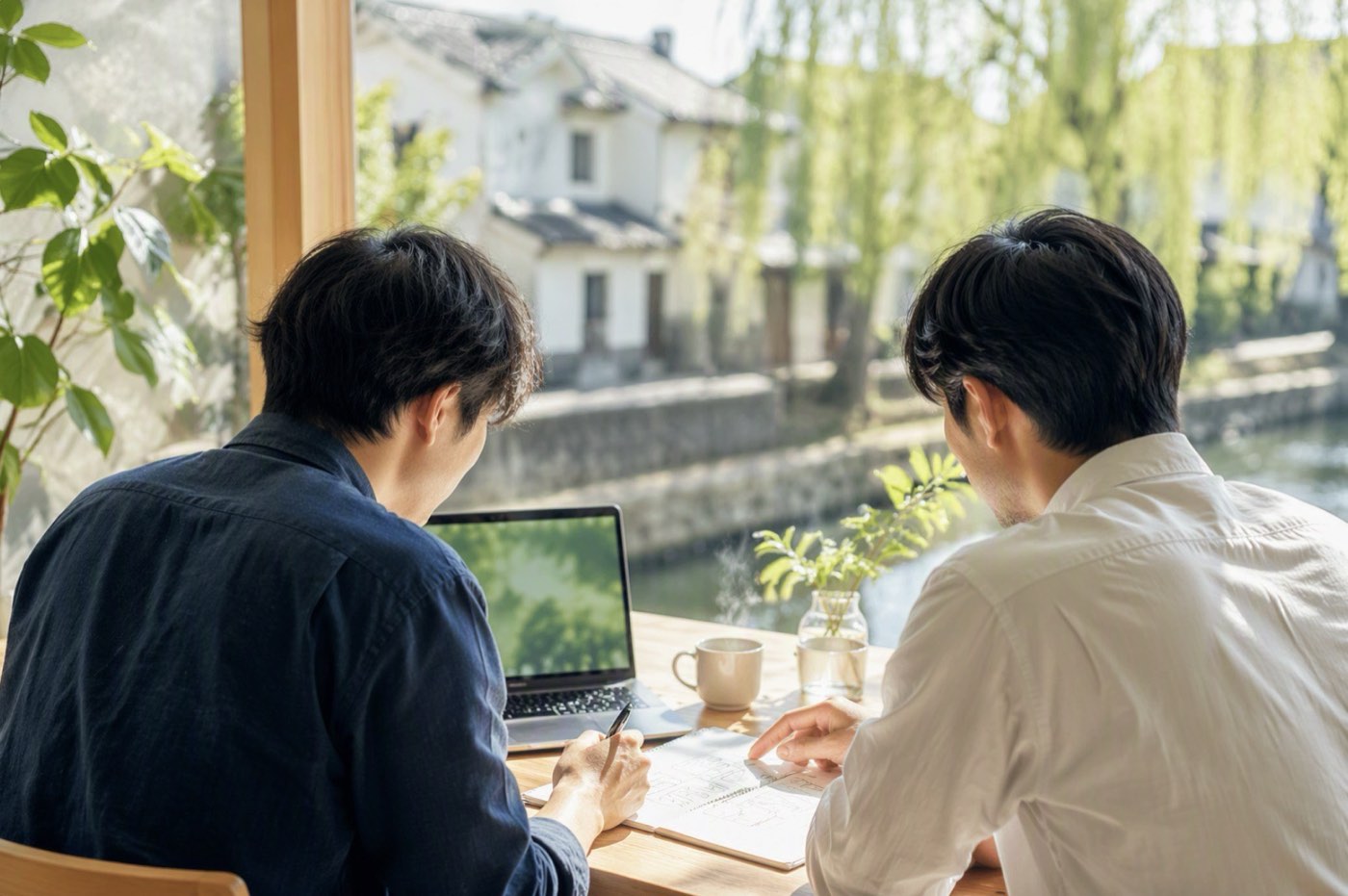 倉敷美観地区の川沿いを歩く人物の後ろ姿。白壁の蔵と柳並木。